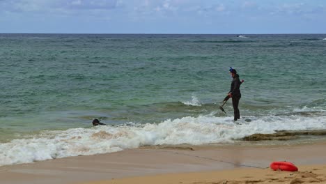 una toma amplia de un buzo mientras se prepara para sumergirse en el océano en las hermosas islas hawaianas.