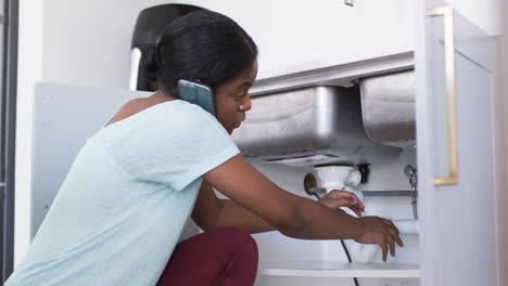 A-young-African-American-woman-is-fixing-a-sink