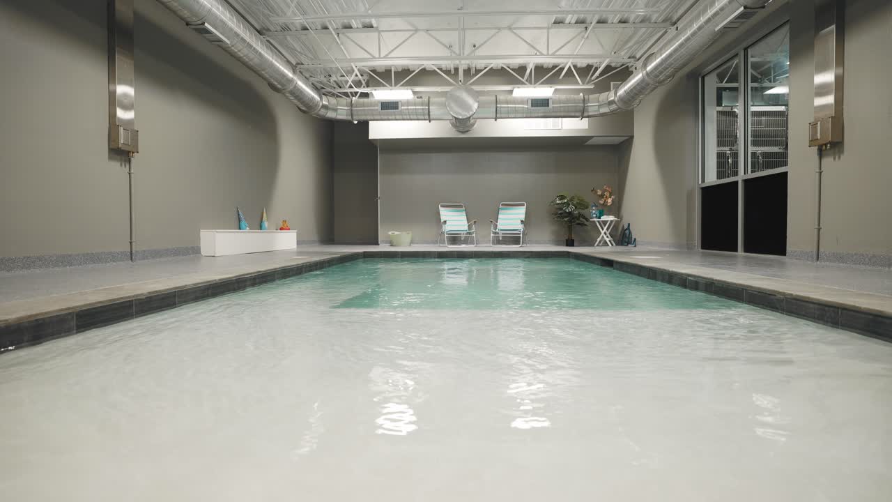 A low-angle shot of an indoor pool with calm water