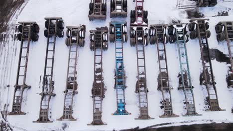 Aerial-sliding-shot-of-empty-trailers-for-shipping-containers,-parked-empty-on-a-parking-lot