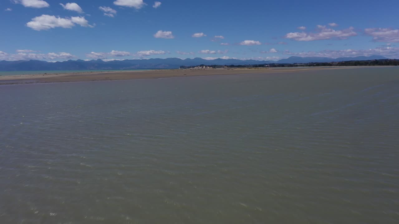 sobrevuelo aéreo de llanuras de barro hacia barras de arena y tussocks en un hermoso día soleado