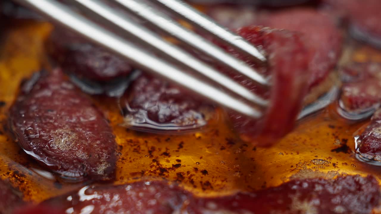Primo piano di salsicce in cottura nell'olio