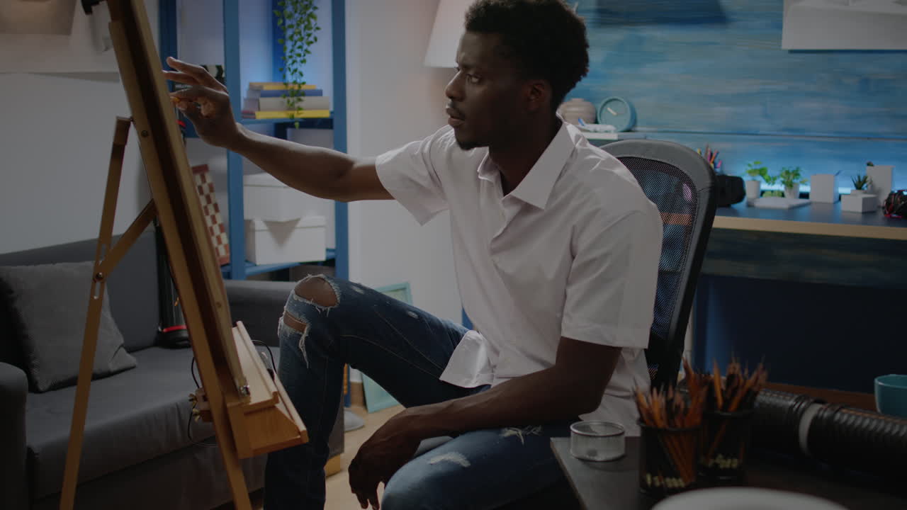 Uomo afroamericano che studia il design di un vaso con una matita