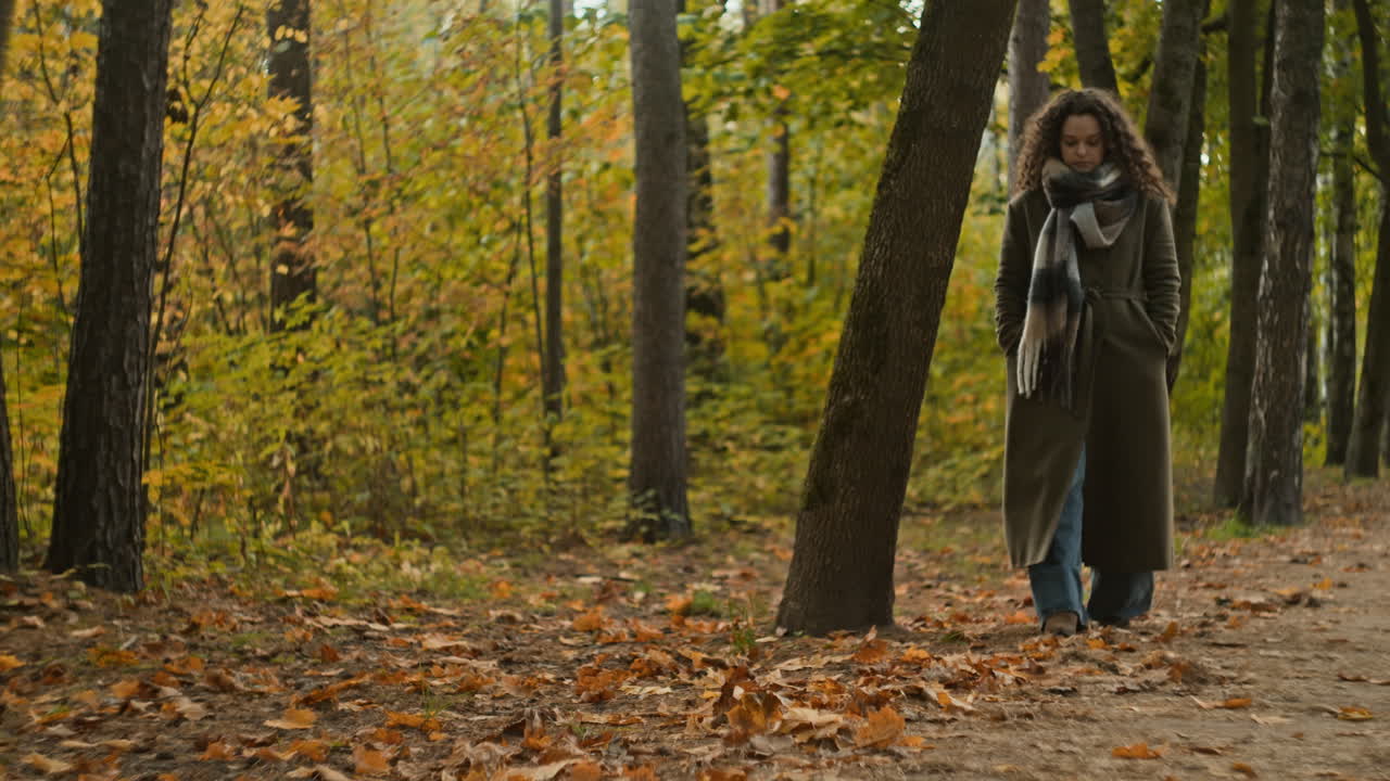 Женщина, гуляющая в осеннем лесу.