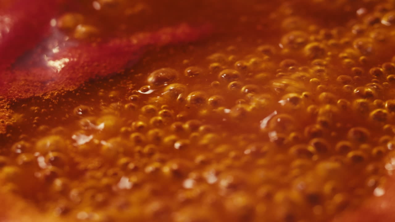 Chicken in tomato sauce is boiling on a frying pan with spices. Cooking tomato sauce curry with chicken fillet. Traditional Italian Mexican Asian dish. High quality studio shot for cafe, restaurant close up.