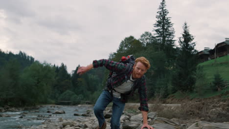 Man-walking-on-rocks-at-river.-Male-hiker-exploring-nature-in-mountains