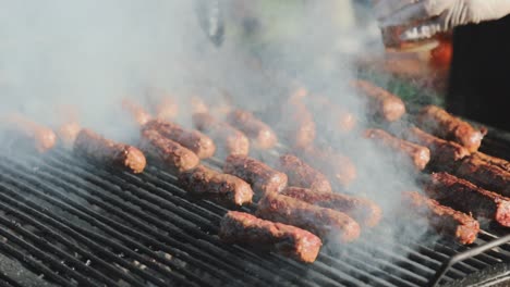 Hornear-Algunas-Carnes-Crudas-En-Una-Parrilla-Muy-Humeante-Y-Brillante-Después-De-Rociarlas-Con-Un-Poco-De-Cerveza