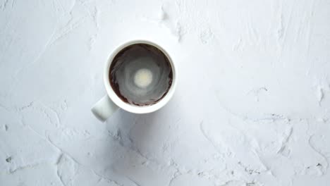 person hand stirring coffee with spoon