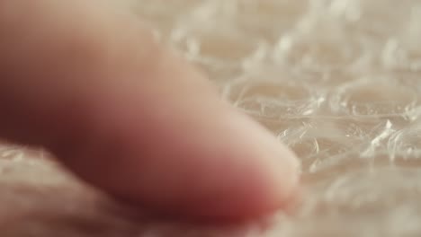 close-up of bubble wrap being touched by a finger