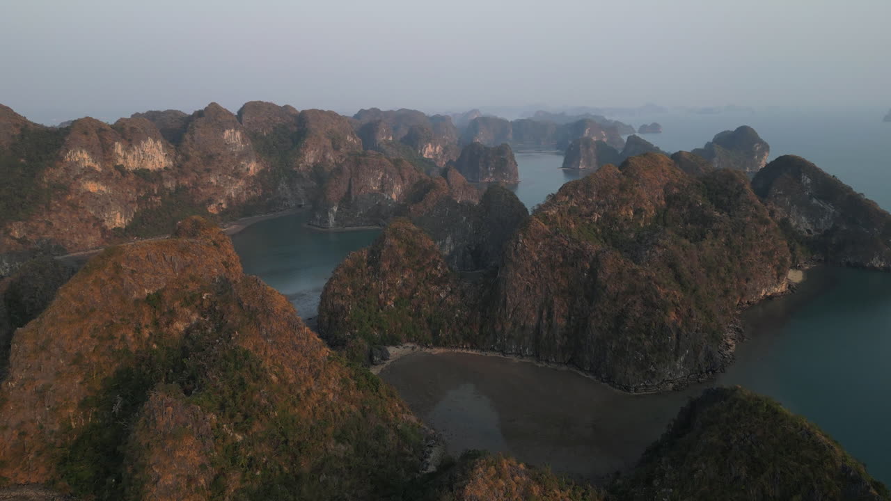 Aerial 4K drone footage over Ha Long Bay, Vietnam, showing tourist boats navigating among limestone karsts and emerald waters