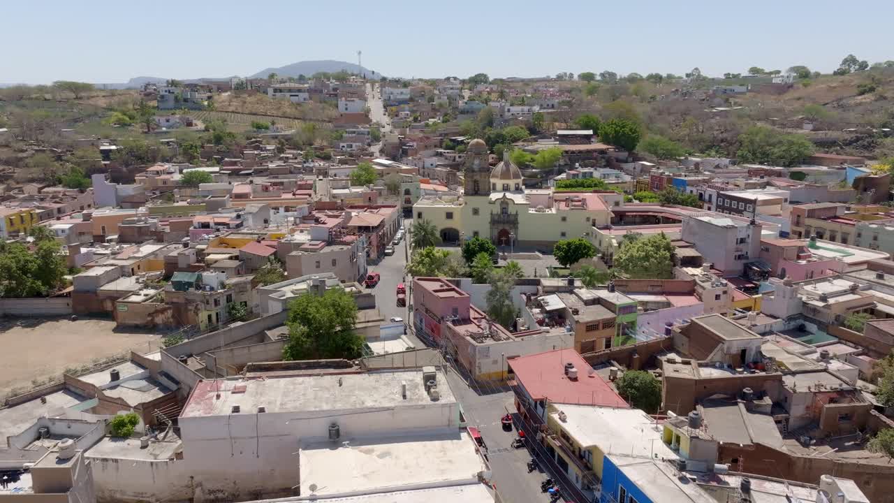 Amatitan town surrounded by agave agricultural fields, The Inmaculada Concepcion Parish catholic church of Immaculate Conception in view, Jalisco, Drone shot