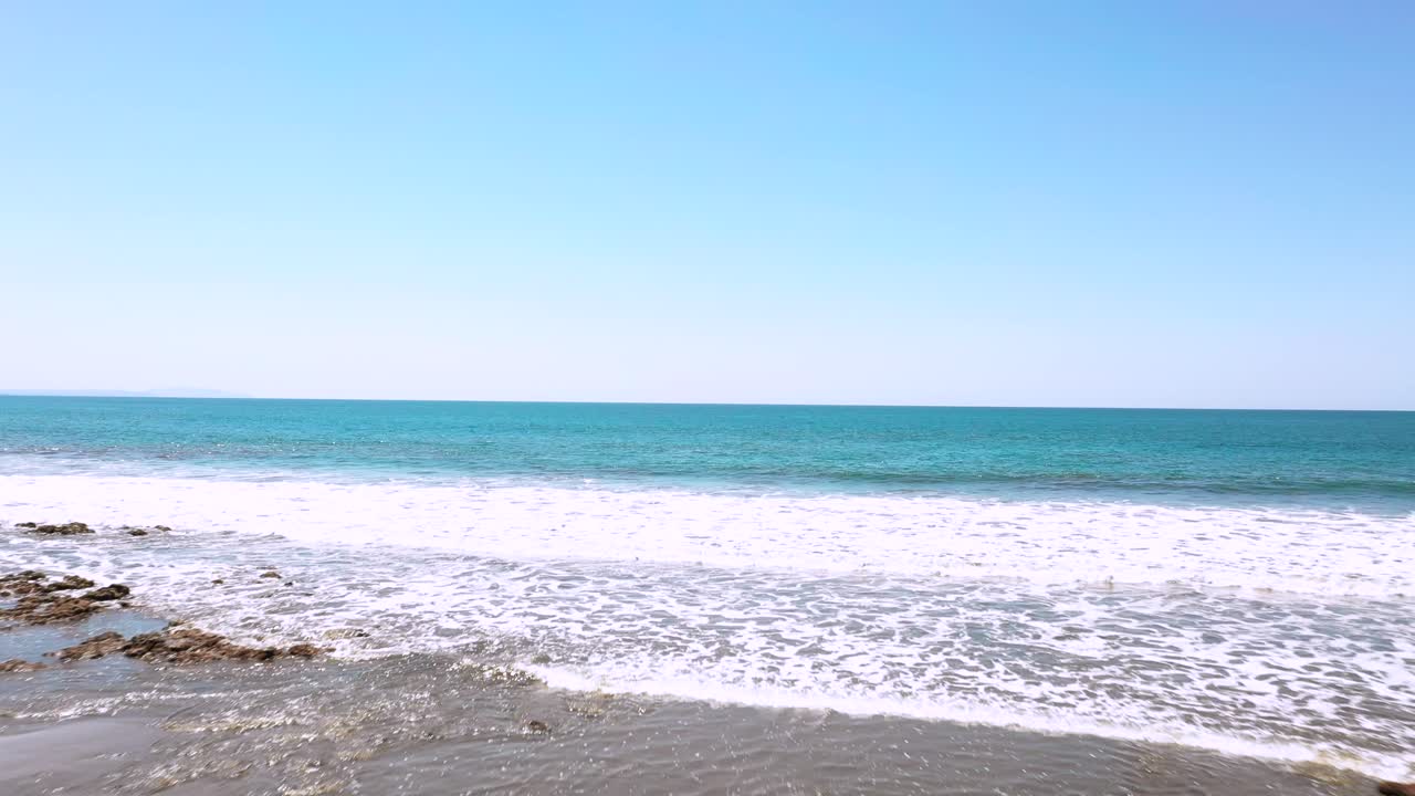 코스타리카, 태평양의 푸른 하늘과 함께 푼타 이슬리타 해변에 파도가 치는 아름다운 공중 드론 영상