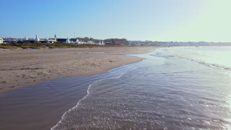 Rückzug-Der-Drohne-über-Nassen-Sand-Und-Kleine-Wellen,-Die-In-Den-Strand-Rollen,-Paternoster