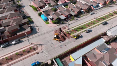 Aerial-orbit-of-heavy-machinery-performing-road-improvements-in-the-street