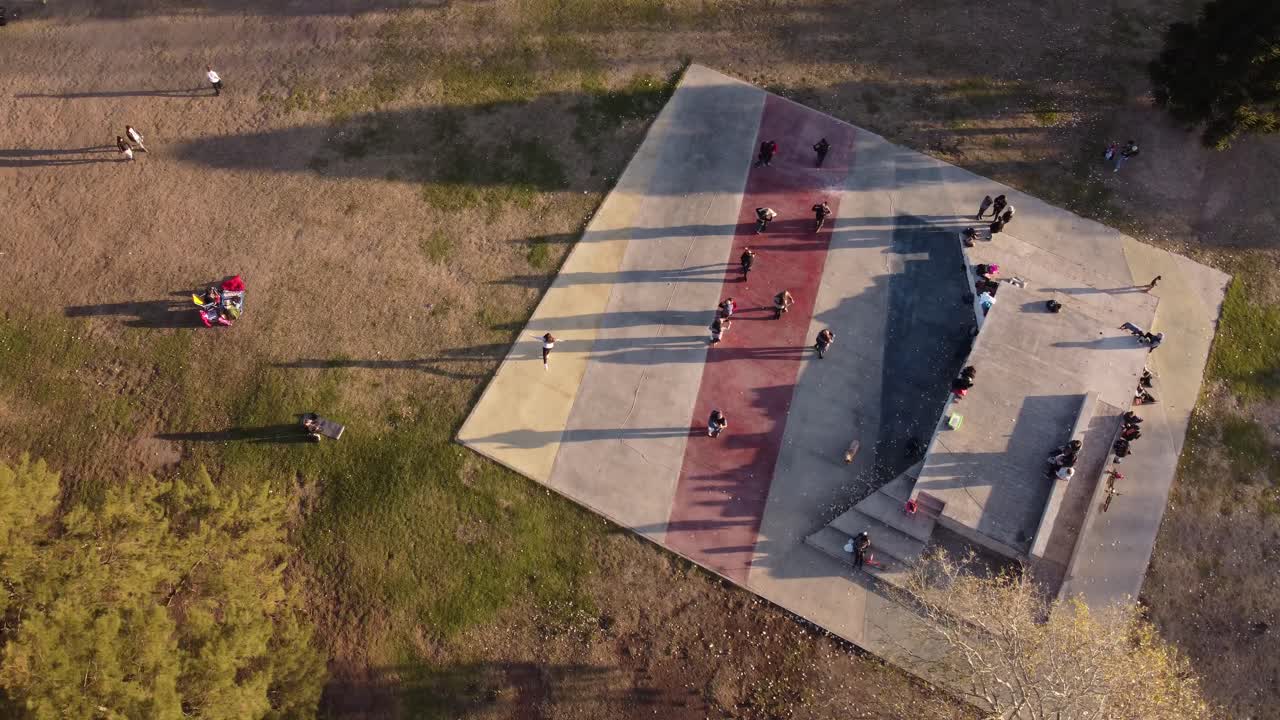 vista aérea al atardecer de parejas de tango bailando al aire libre en una clase en el parque de buenos aires