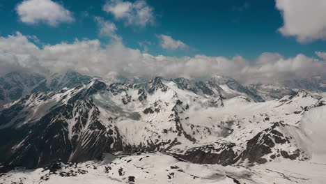 air flight through mountain clouds over beautiful snow-capped peaks of mountains and glaciers.