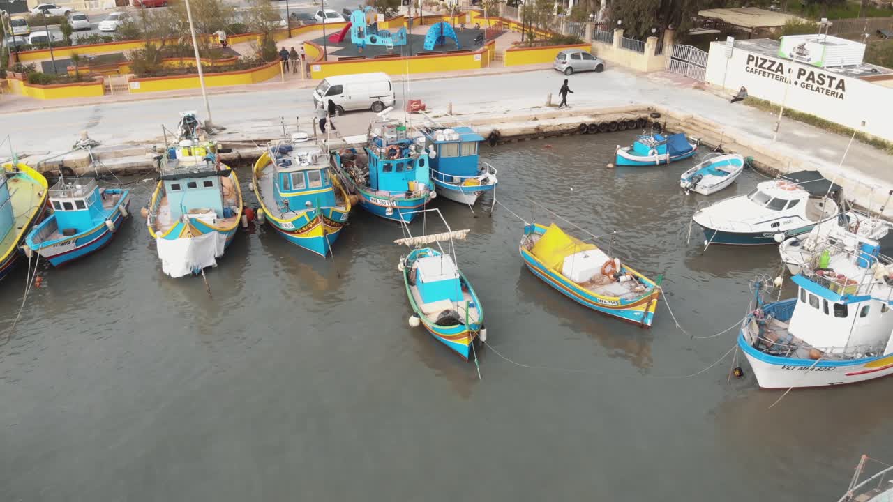 Aerial Push In Shot of Bobbing Fishing Boats In Marsaxlokk Malta