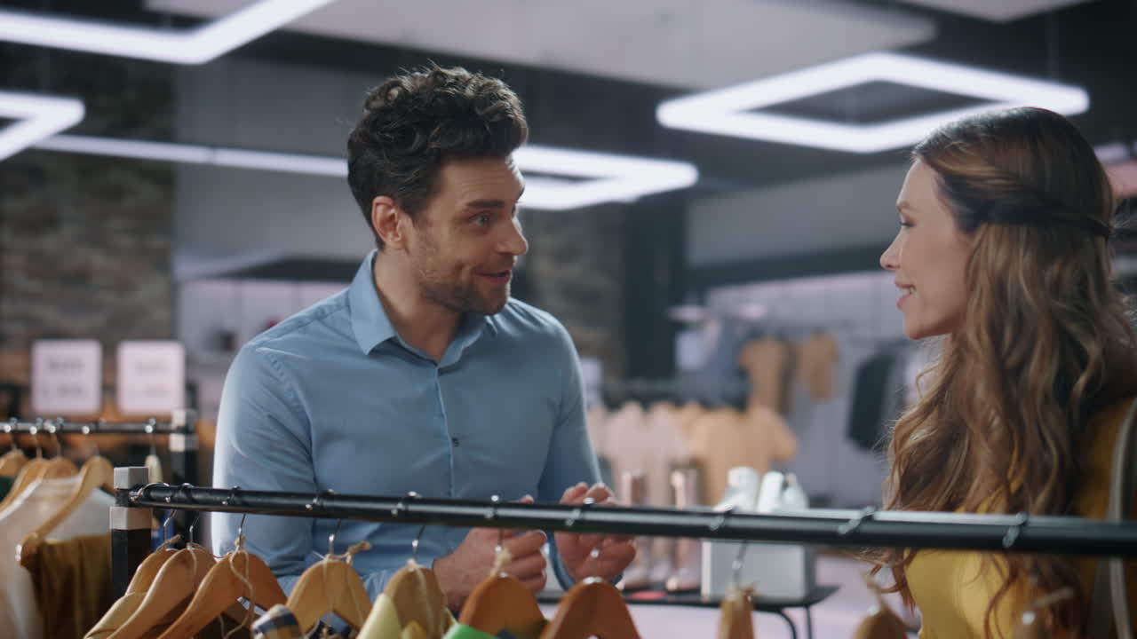 mujer adicta a las compras eligiendo ropa en una boutique. asistente hablando con el cliente