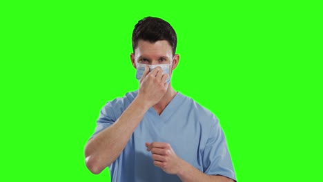 Caucasian-male-doctor-wearing-face-mask-on-green-screen-background