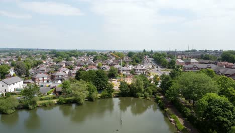 Aerial-view-across-detached-neighbourhood-property-flyover-to-lakeside-red-brick-British-townhouse-building-site