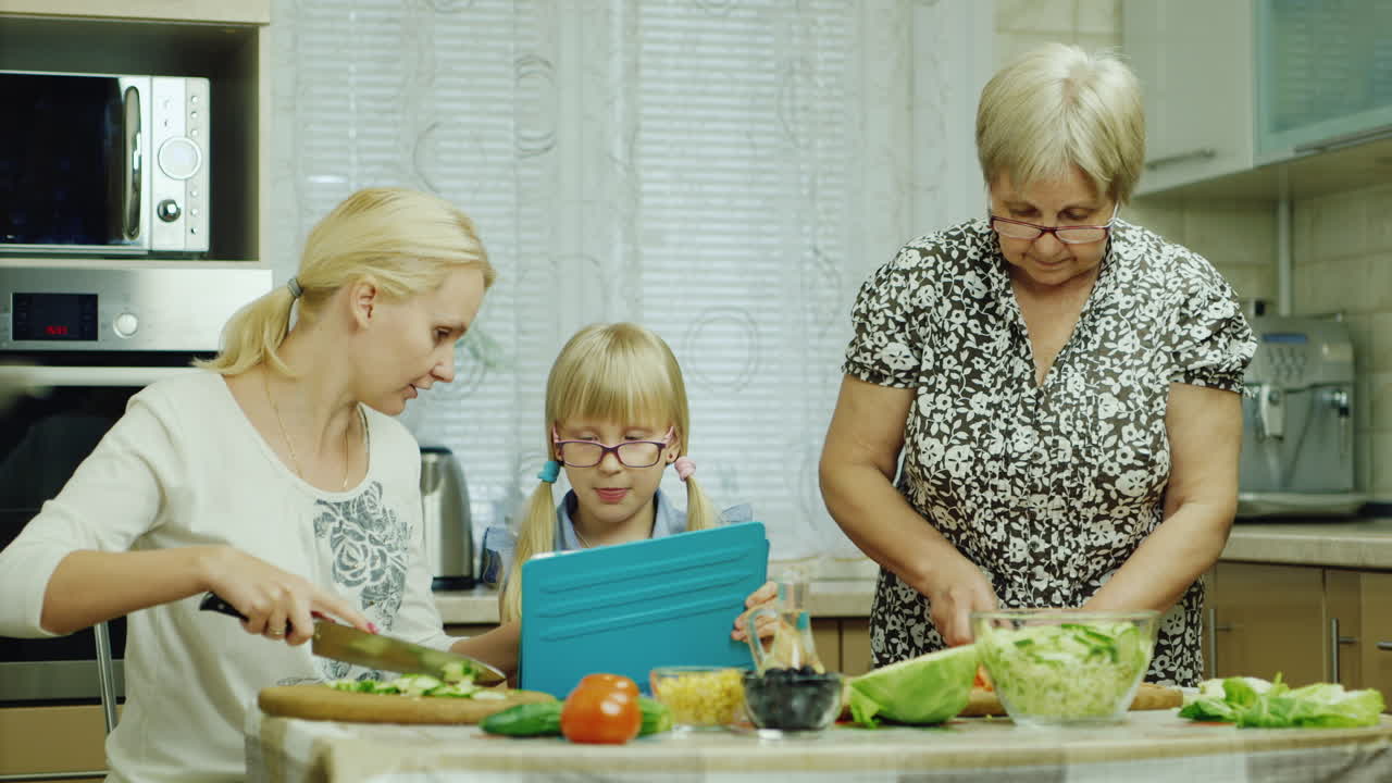 бабушка мать и внучка готовят вместе салат на кухне