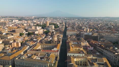 Vista-Aérea-De-Via-Etnea-Con-El-Volcán-Monte-Etna-Al-Fondo.