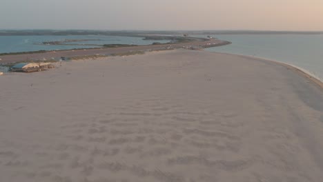 Cinematic-drone---aerial-shot-of-the-green-and-sandy-nature-beach-at-sunset-with-tourists-and-people-with-Buggykiting-at-Zeeland-at-the-north-sea,-Netherlands,-30p