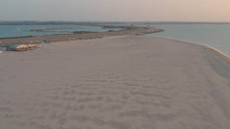 drone cinemático - toma aérea de la playa natural verde y arenosa al atardecer con turistas y personas con buggykiting en zelanda en el mar del norte, países bajos, 30p
