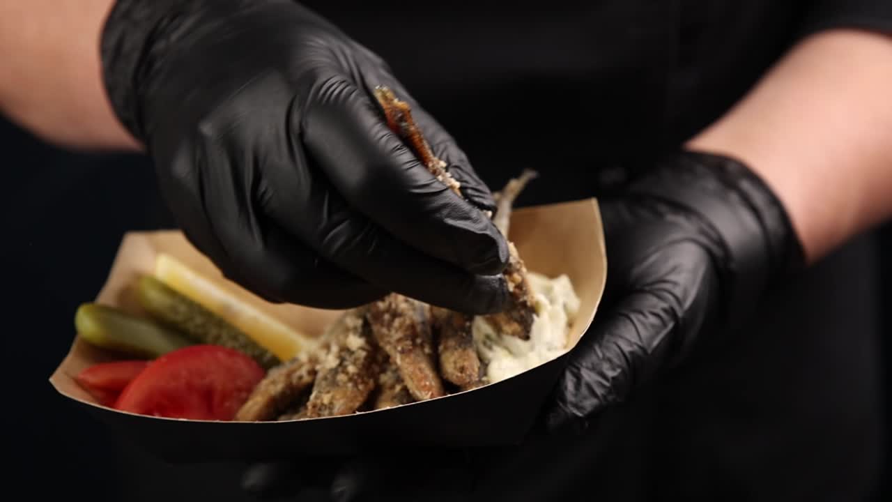 chef preparando un bocadillo de pescado frito
