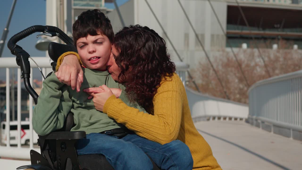 A mother embraces her disabled son in a wheelchair with love and tenderness