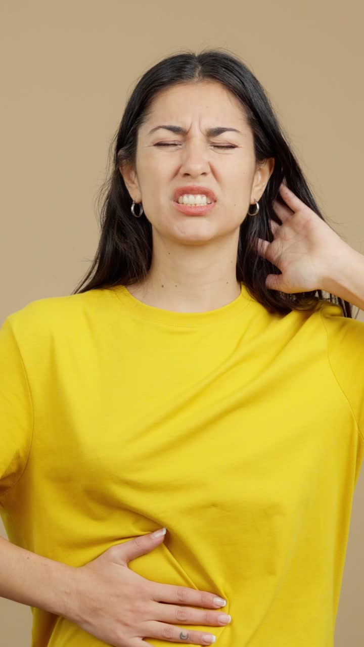 A woman experiencing discomfort and pain, including headache and stomach issues