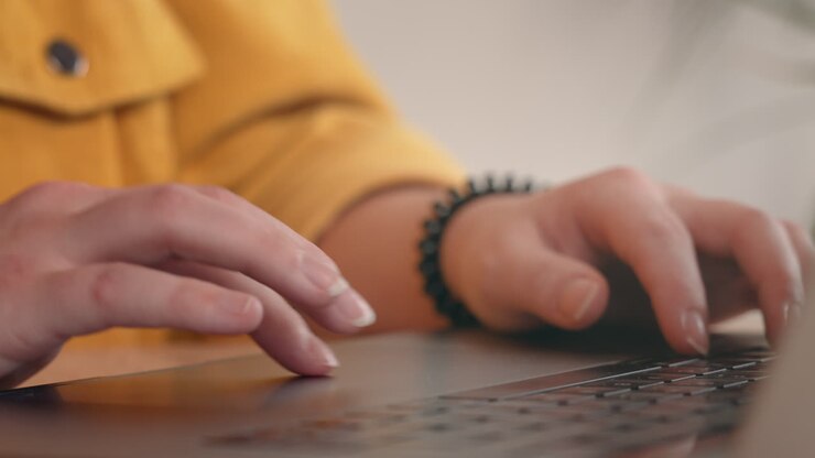 Close up of millennial woman hands working from home using MacBook trackpad