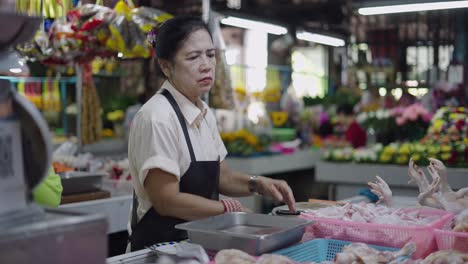 woman preparing chicken at a local market