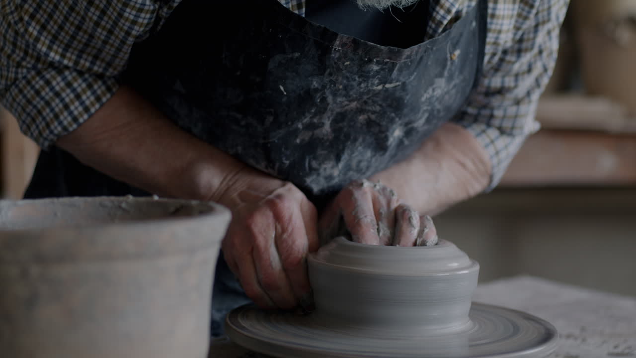 Senior Potter Shaping a Bowl on a Pottery Wheel