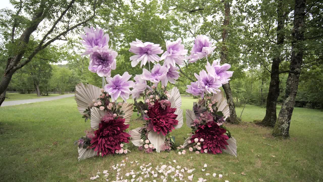 forest wedding setting with lilac crepe flowers and roses, dolly wide shot moving backward