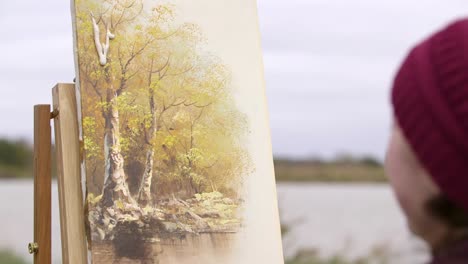 woman watches bird poop fall on painting of forest