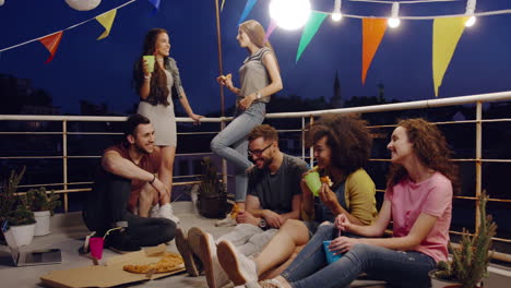 friends enjoying rooftop party at night