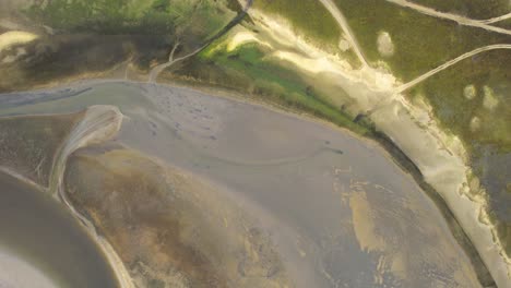 Eine-Exquisite-Aufnahme-Der-Kurvenreichen-Seiten-Der-Insel-Texel,-Die-Sich-Sanft-In-Einen-Fliegenden-Entlang-Der-Unbefestigten-Straße-Im-Texeler-Watten-nationalpark,-Niederlande,-Verwandeln