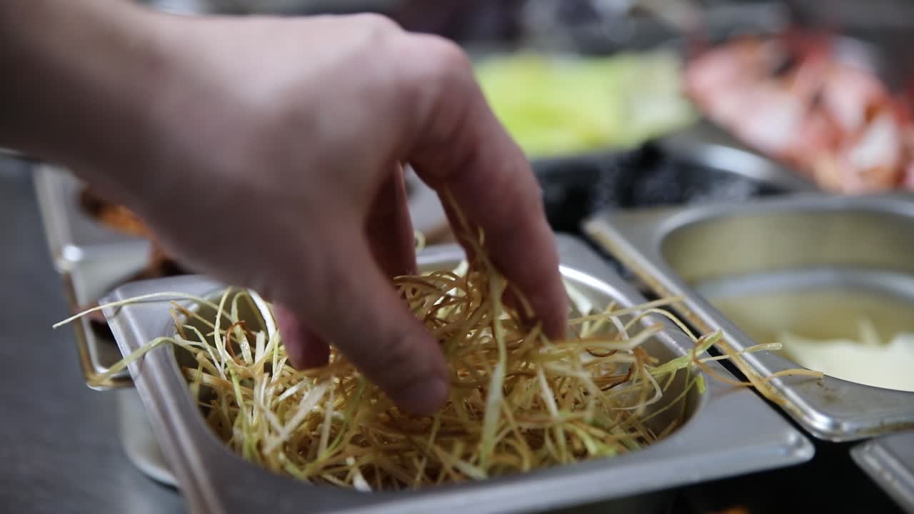 Chef che prepara cipollotti fritti croccanti in cucina