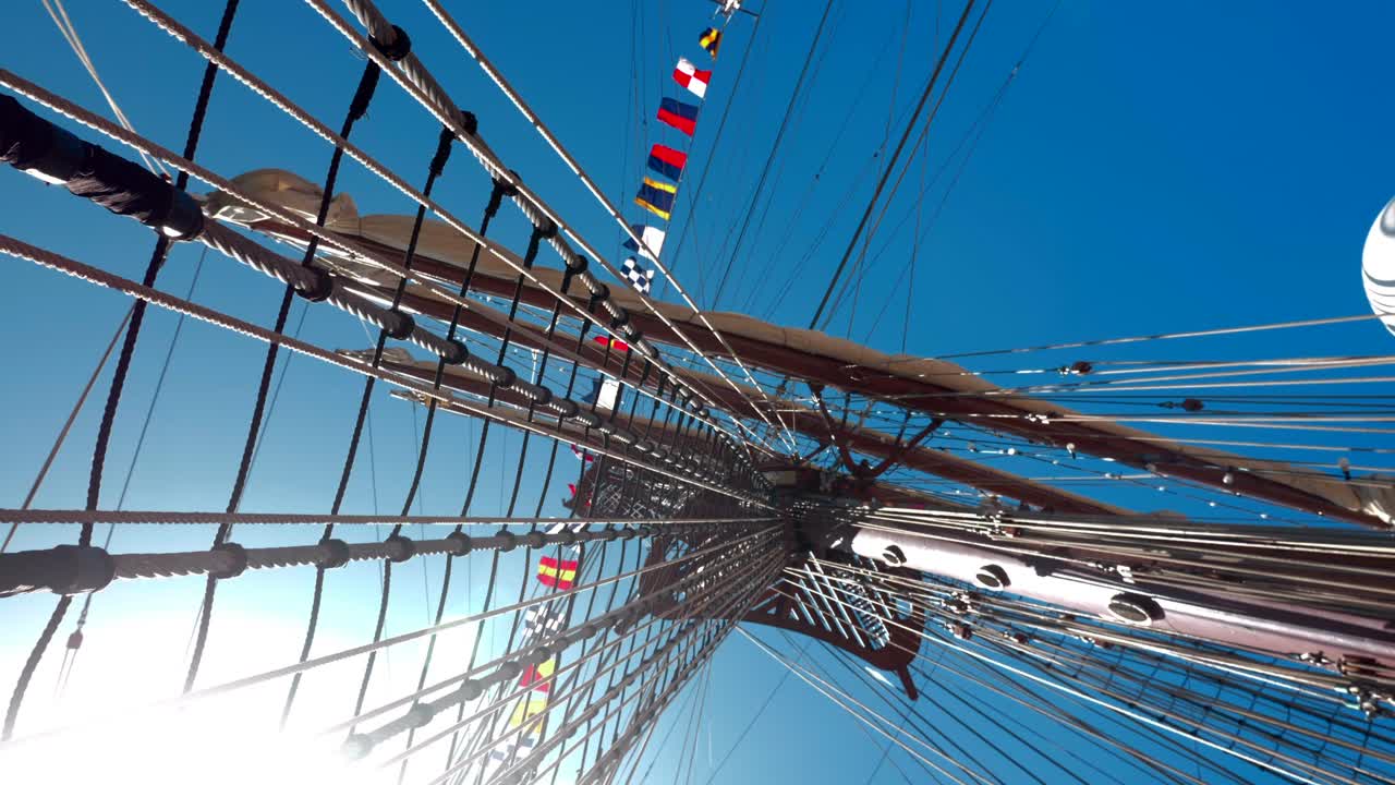 태양의 빛은 높은 배, 항해 보트, 로프와 기계를 통해 빛납니다.