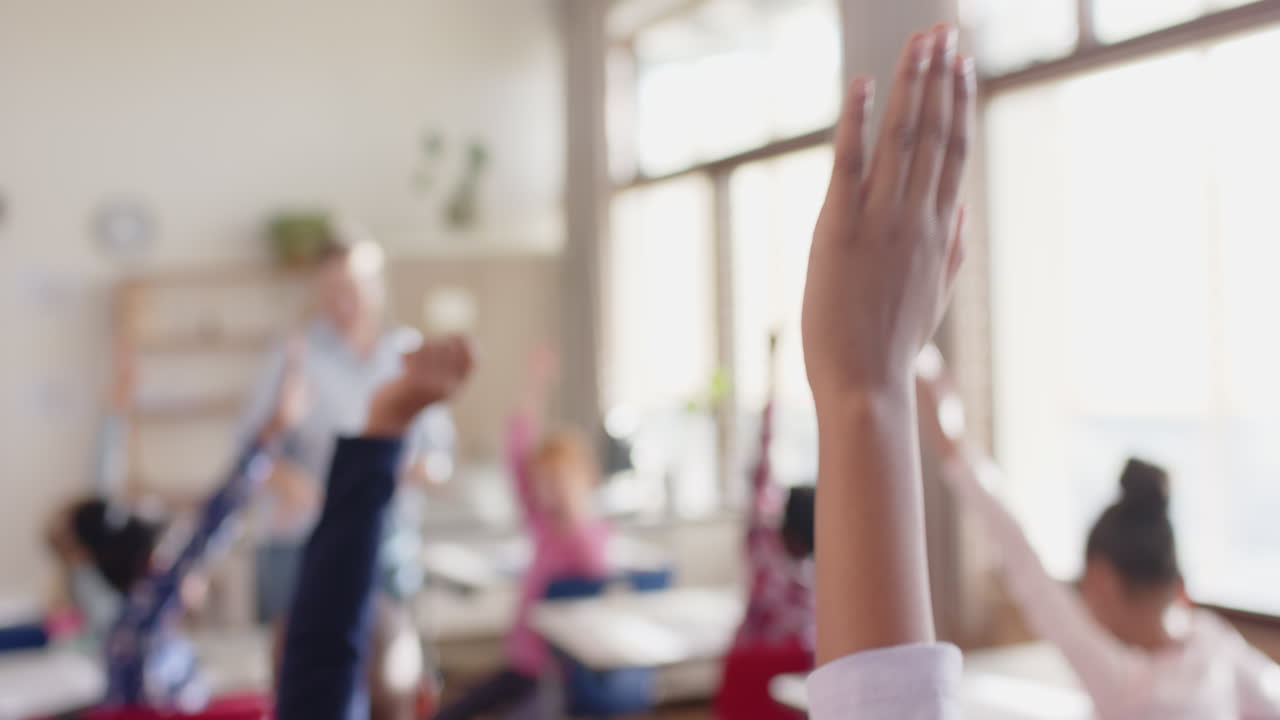 In school, students raising hands in classroom, actively participating in lesson