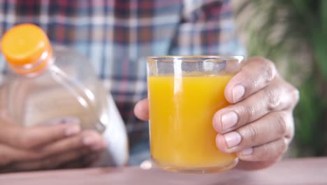 person holding a glass of orange juice