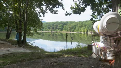 Off-Grid-Camping-In-Der-Nähe-Eines-Malerischen-Süßwassersees-Mit-An-Bäumen-Aufgehängten-Gegenständen