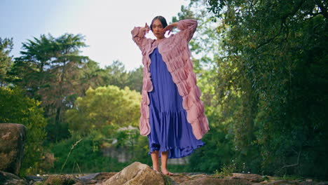 hermosa chica de la moda moviendo el cuerpo sensualmente de pie en la belleza de la naturaleza del bosque.