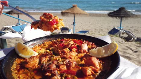 Paella-Am-Strand-Mit-Einer-Schöpfkelle-Schöpfen,-Sommerurlaubsaufnahme,-Filmmaterial-Gefilmt-In-Marbella,-Spanien