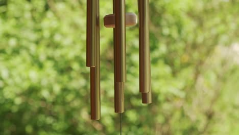 metal wind chime natural green background slow motion 120p