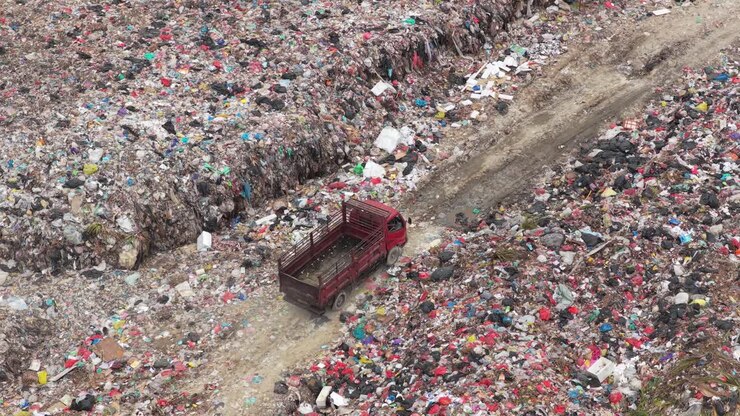 Camion rosso che attraversa una grande discarica a Bali