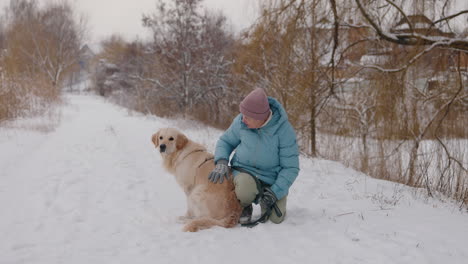 woman and golden retriever in winter park
