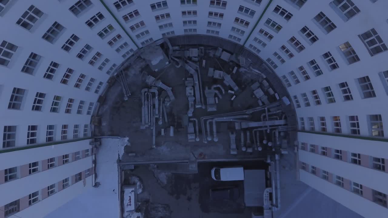 지붕 에 기계적 인 장비 가 있는 구부러진 아파트 건물 의 공중 사진