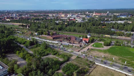 historic steam locomotive shed and trains depot with surrounding urban city berlin germany landscape, industrial heritage. amazing aerial view flight panorama orbit drone
